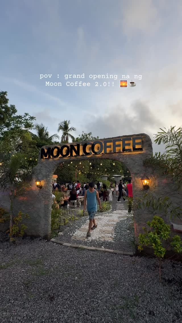 Moon Coffee stone arch entrance at golden hour during the grand opening of Branch 2.0, guests walking through the entry path